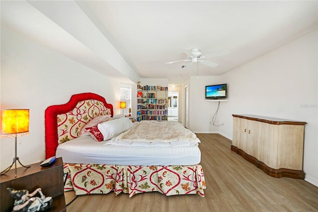 bedroom with ceiling fan, baseboards, and wood finished floors