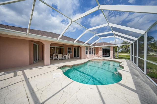 outdoor pool with a patio, outdoor dining space, and glass enclosure