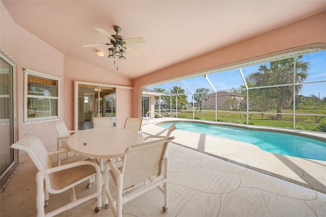 pool featuring ceiling fan, glass enclosure, and a patio area