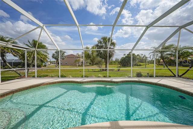 outdoor pool featuring glass enclosure, a yard, and a patio