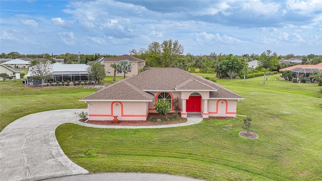 mediterranean / spanish home with driveway, roof with shingles, a residential view, stucco siding, and a front yard