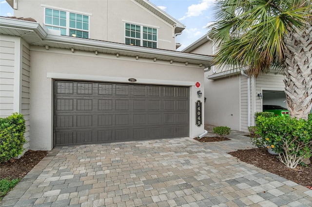 garage with decorative driveway