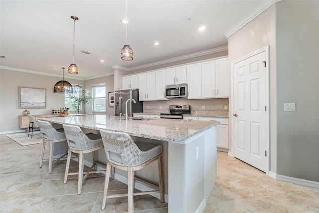 kitchen with visible vents, a spacious island, stainless steel appliances, white cabinetry, and crown molding