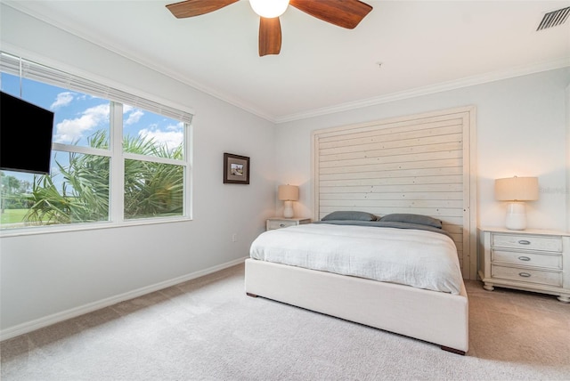 carpeted bedroom with visible vents, a ceiling fan, crown molding, and baseboards