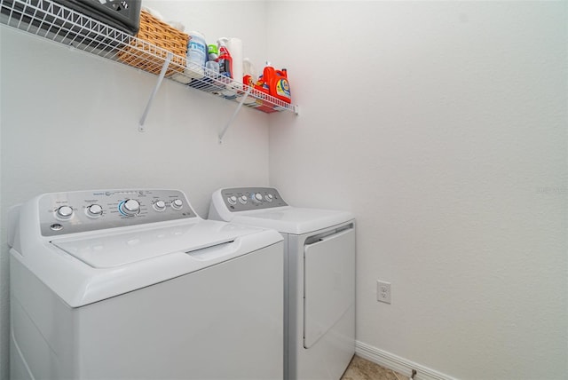 washroom with baseboards, laundry area, and washer and clothes dryer