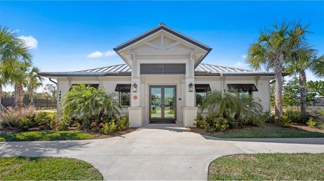 exterior space with a standing seam roof, french doors, and metal roof