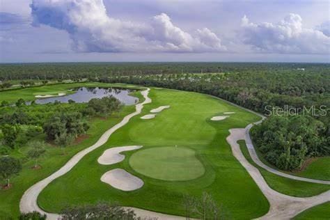 birds eye view of property with golf course view, a view of trees, and a water view