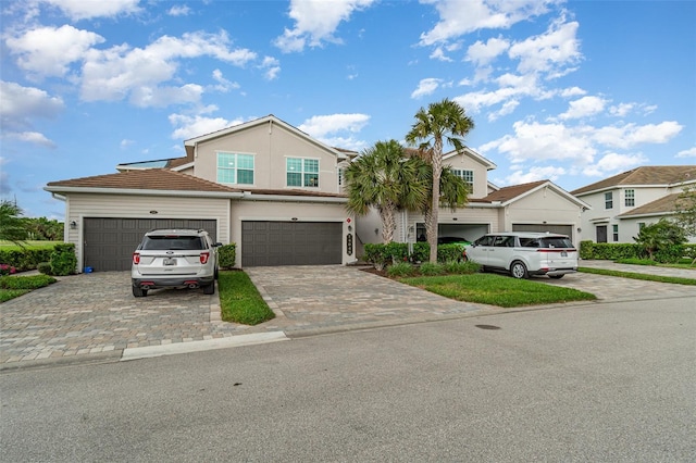 view of front of house with decorative driveway and stucco siding