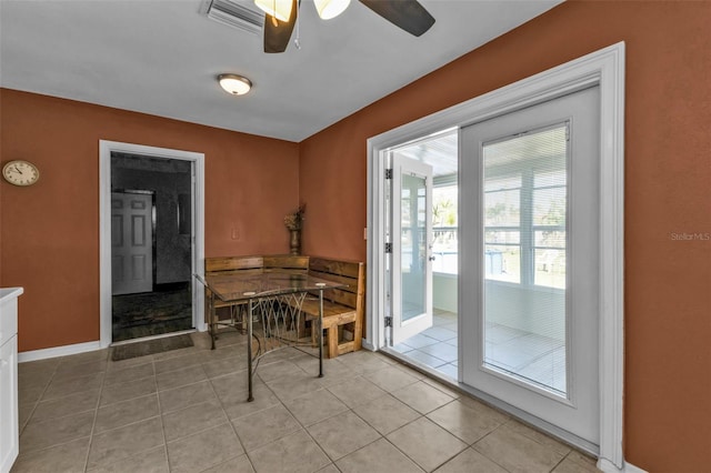 dining room with light tile patterned floors, ceiling fan, visible vents, and baseboards