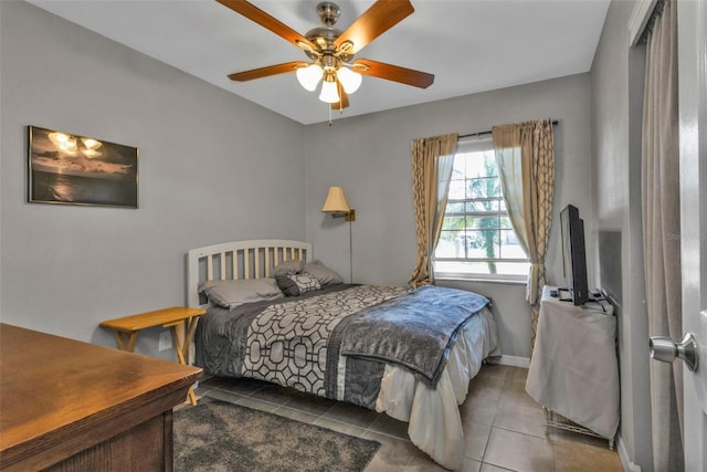 tiled bedroom featuring a ceiling fan and baseboards