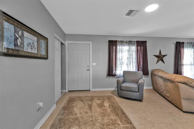 living area featuring light tile patterned floors, baseboards, and visible vents