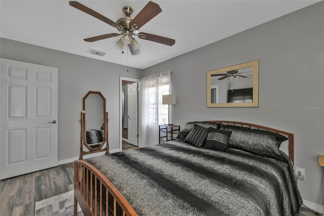 bedroom featuring visible vents, baseboards, ceiling fan, and wood finished floors