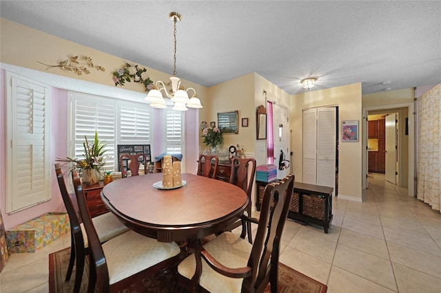 dining area featuring light tile patterned flooring and an inviting chandelier