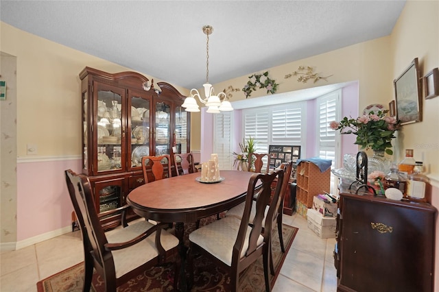 dining room featuring a textured ceiling, baseboards, a notable chandelier, and light tile patterned flooring