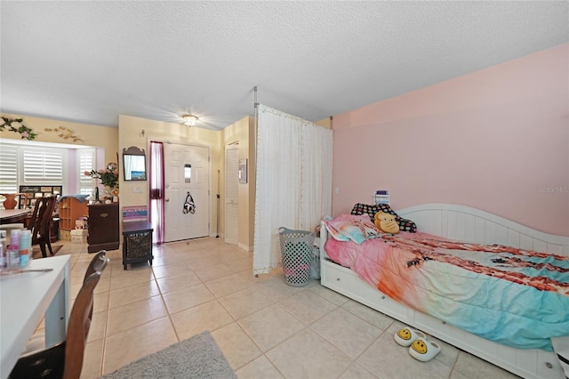 bedroom with a textured ceiling and light tile patterned flooring