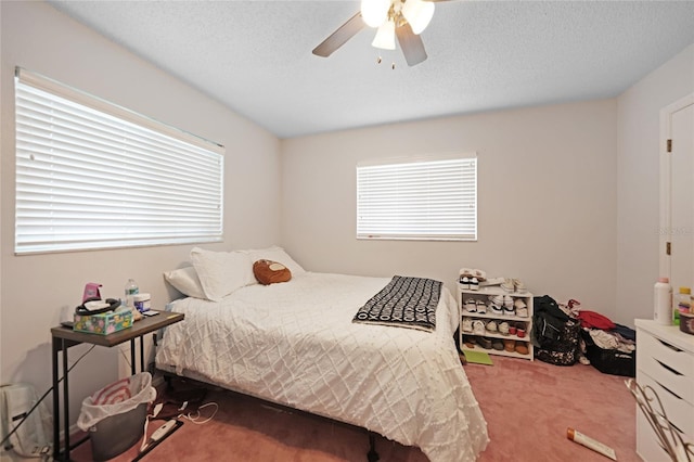 bedroom with carpet floors, multiple windows, and a textured ceiling