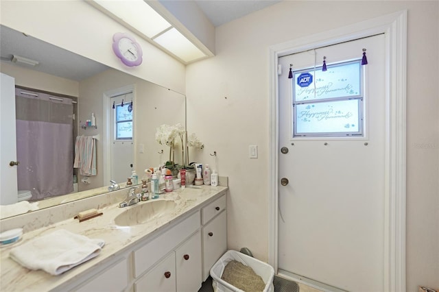 bathroom with toilet, curtained shower, and vanity