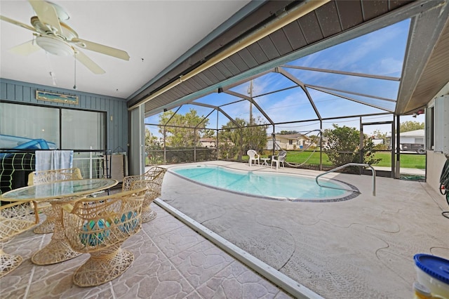 outdoor pool with a patio area, glass enclosure, outdoor dining area, and a ceiling fan