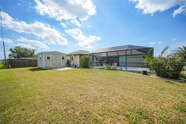 view of yard featuring an outdoor pool, a lanai, fence, and an outdoor structure