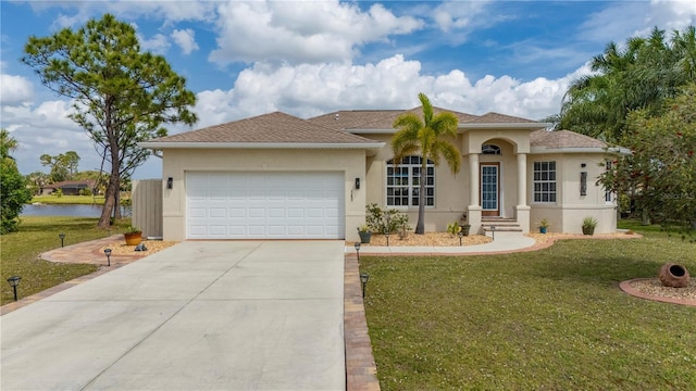 view of front of home featuring a front lawn, a water view, concrete driveway, stucco siding, and an attached garage