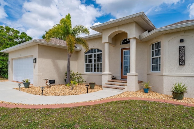 view of front of house featuring an attached garage, driveway, and stucco siding