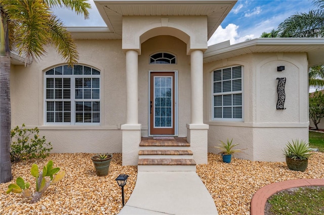 entrance to property featuring stucco siding