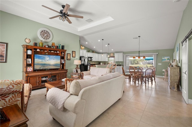 living area featuring visible vents, baseboards, vaulted ceiling, light tile patterned floors, and a ceiling fan