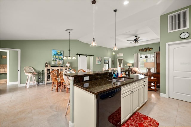 kitchen featuring visible vents, a sink, black dishwasher, pendant lighting, and a barn door