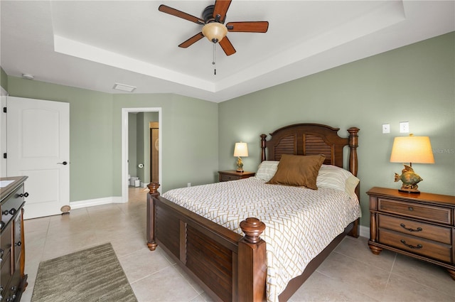 bedroom with light tile patterned flooring, ceiling fan, a raised ceiling, and baseboards