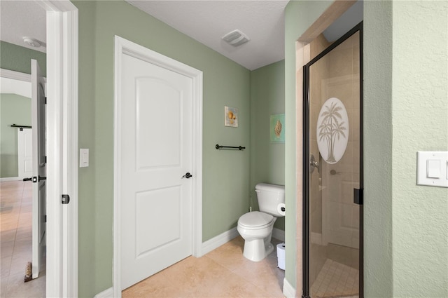 full bathroom with tile patterned floors, a stall shower, toilet, and baseboards