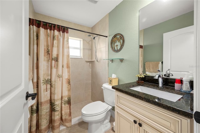 bathroom featuring tile patterned flooring, toilet, tiled shower, and vanity