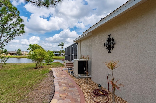 exterior space with a lanai, cooling unit, and a water view