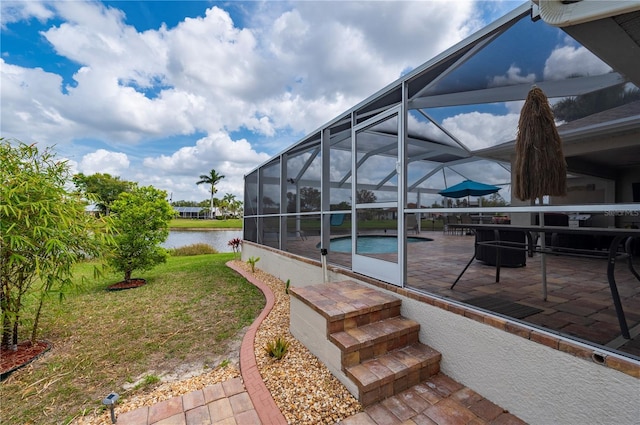 exterior space with a patio, an outdoor pool, a water view, and a lanai