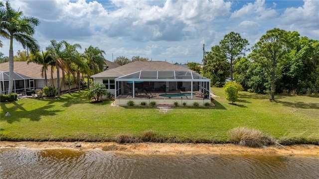 back of property with glass enclosure, an outdoor pool, a lawn, and a water view