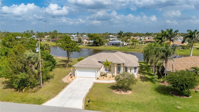 view of front of house with an attached garage, stucco siding, a front lawn, concrete driveway, and a water view