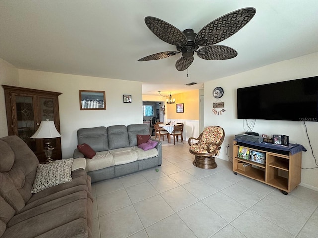 living area with ceiling fan with notable chandelier and light tile patterned flooring