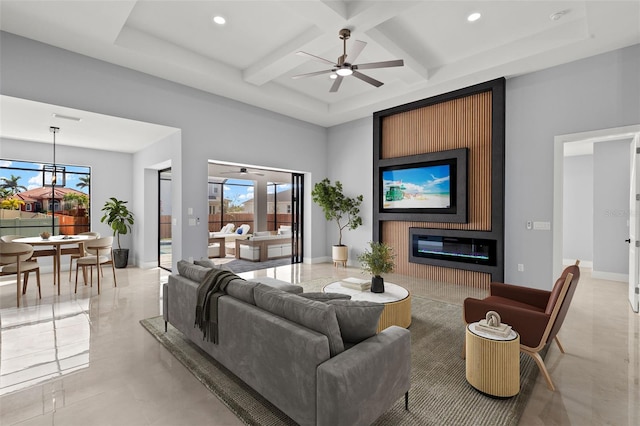 living area featuring a wealth of natural light, coffered ceiling, a fireplace, and a towering ceiling