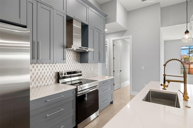 kitchen with a sink, wall chimney exhaust hood, appliances with stainless steel finishes, and gray cabinets