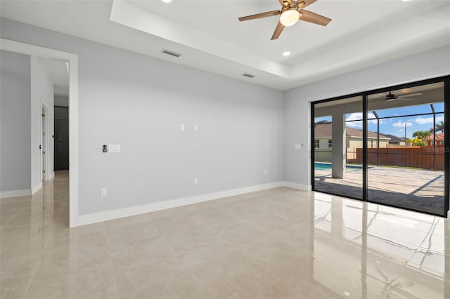 unfurnished room featuring a tray ceiling, recessed lighting, visible vents, and baseboards