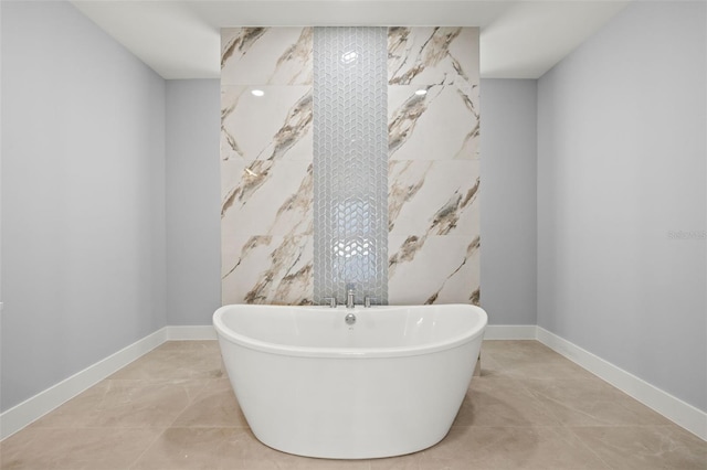 full bathroom featuring a freestanding tub and baseboards