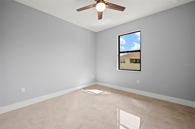 unfurnished room featuring ceiling fan and baseboards