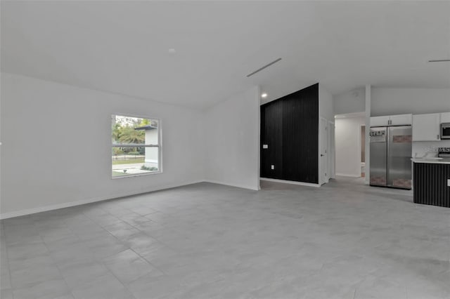 unfurnished living room featuring vaulted ceiling, visible vents, and baseboards