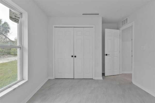 unfurnished bedroom featuring baseboards, visible vents, and a closet