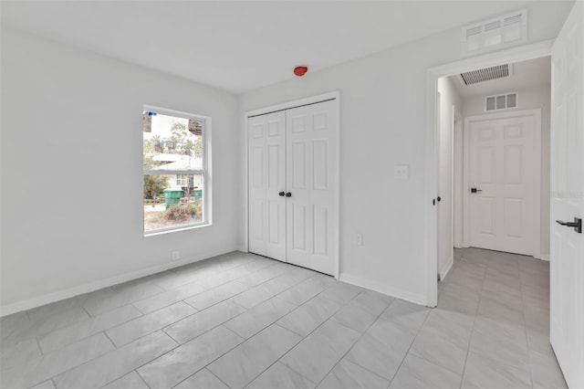 unfurnished bedroom featuring visible vents, baseboards, and a closet