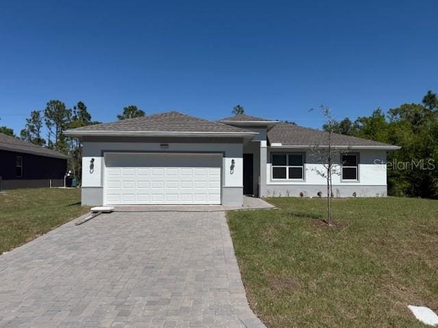 view of front of home with a garage, a front lawn, decorative driveway, and stucco siding