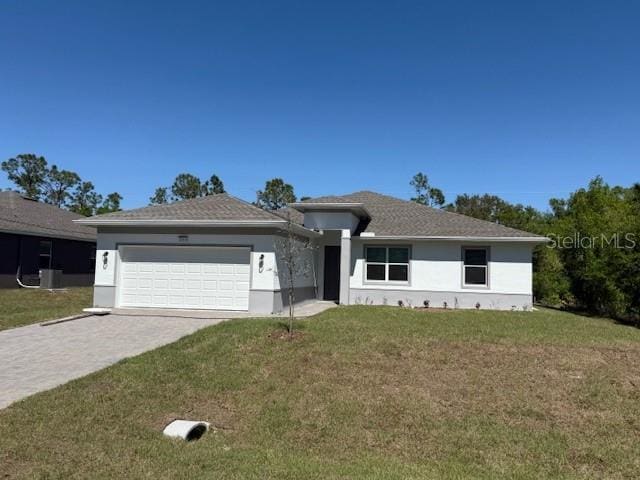 view of front of home with a garage, a front lawn, decorative driveway, and stucco siding