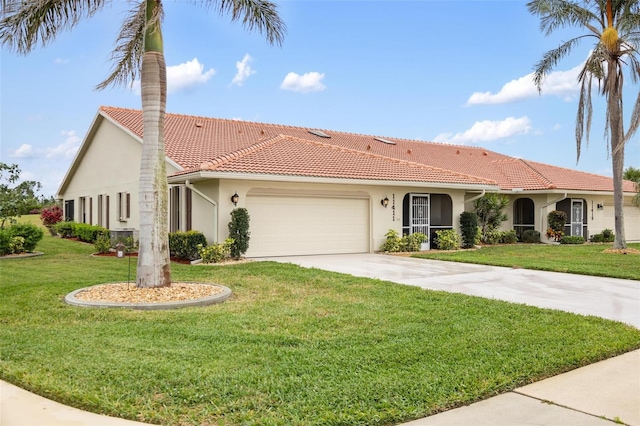 mediterranean / spanish house with concrete driveway, a tile roof, a front yard, stucco siding, and a garage