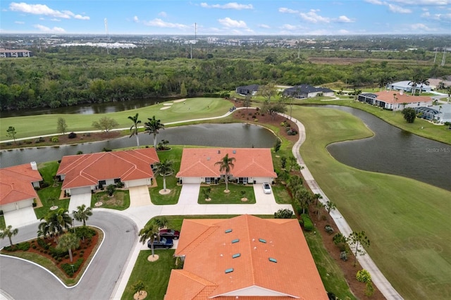 drone / aerial view with a water view and golf course view