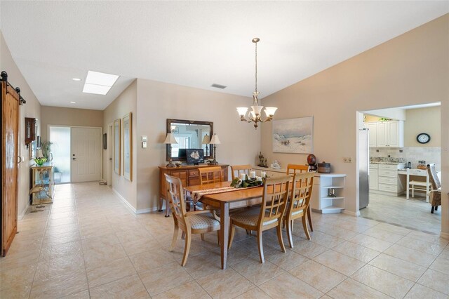 dining area featuring visible vents, baseboards, a barn door, lofted ceiling, and a notable chandelier