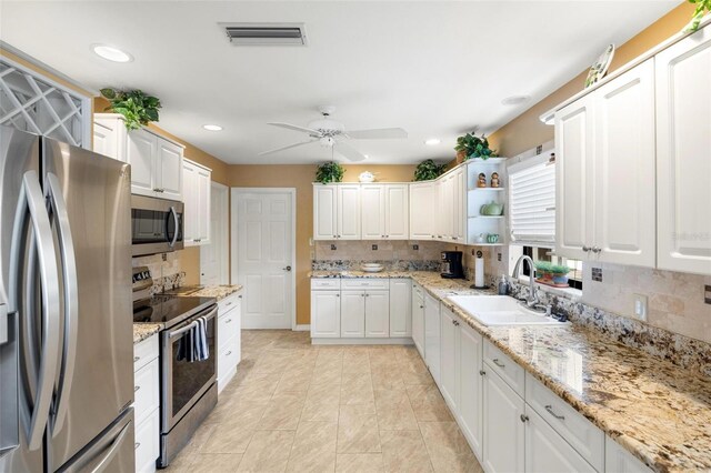 kitchen with visible vents, a sink, white cabinetry, appliances with stainless steel finishes, and decorative backsplash